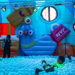 A recreational installation filled with balls, inflated figures and people.